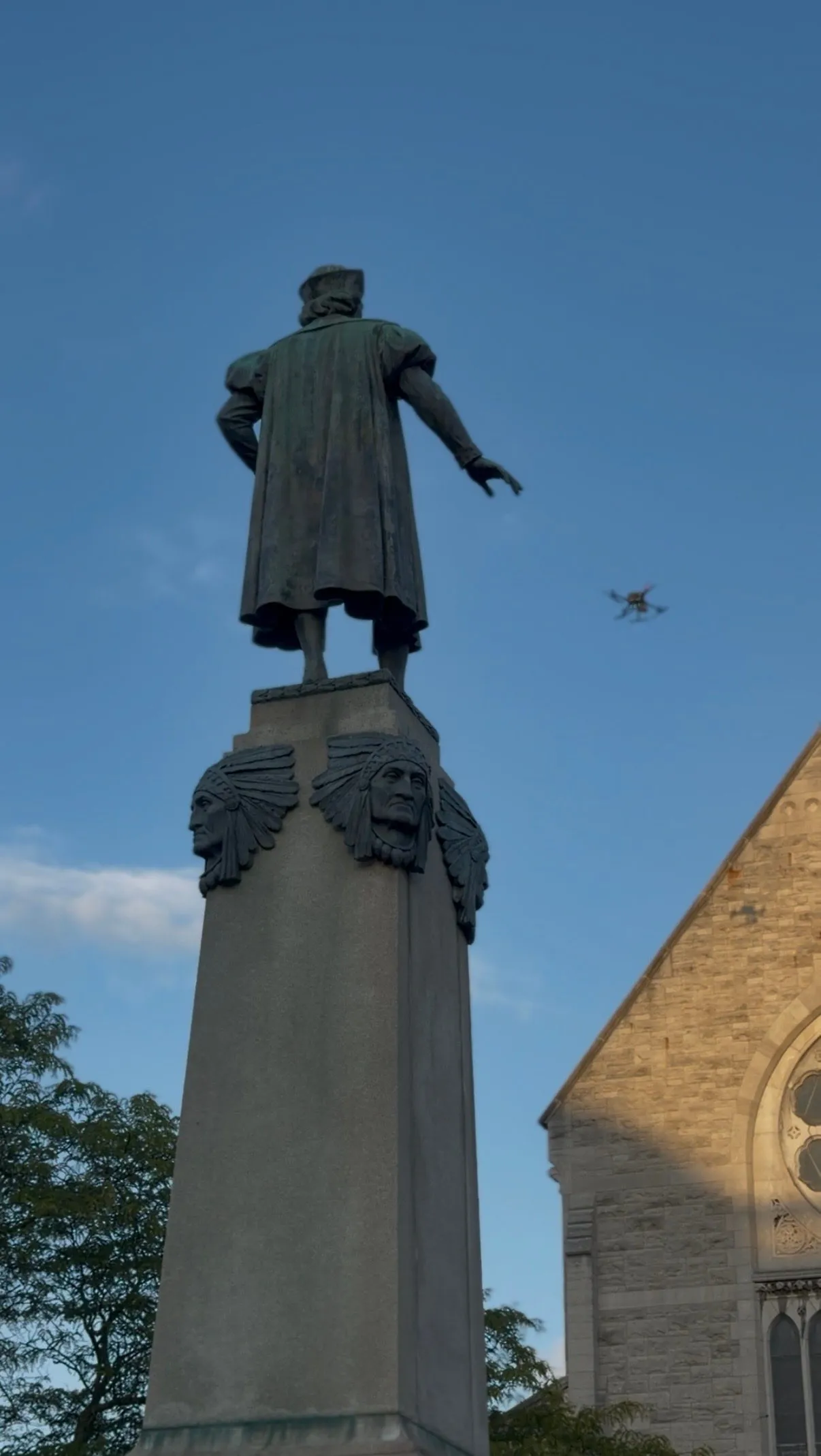 Looking up at the bronze figure on top of the Columbus Monument against a blue sky